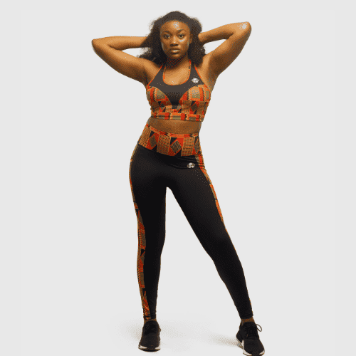 Full body view of woman wearing black high waisted leggings with Kente print detailing