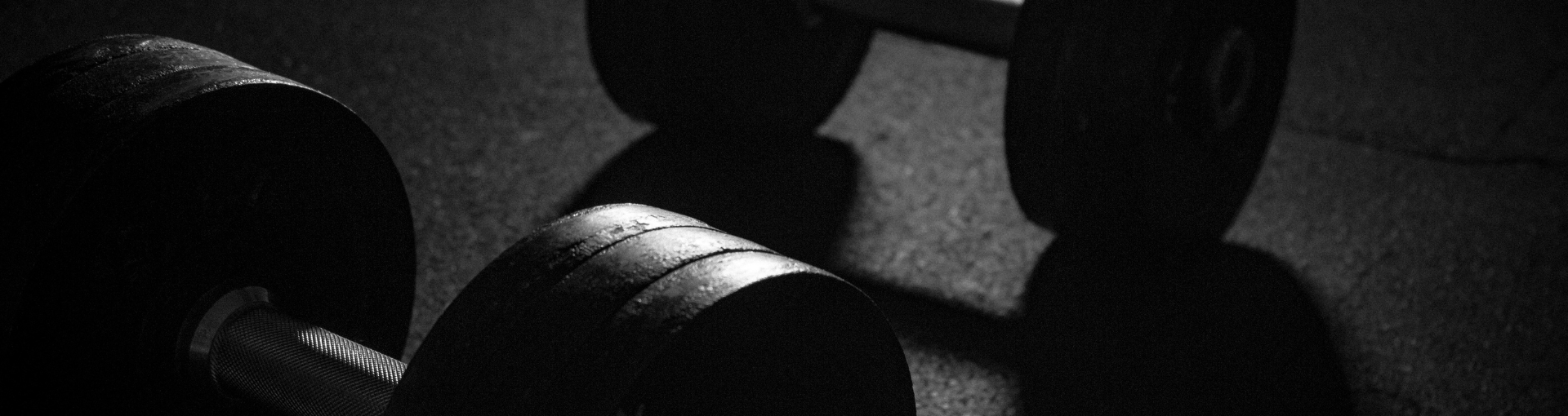 Black and white dumbbells on gym floor, fitness equipment