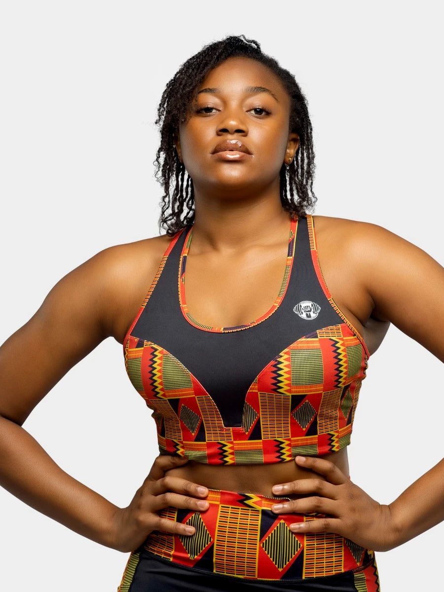 Woman wearing a colorful sports bra and leggings with a geometric pattern on a white background